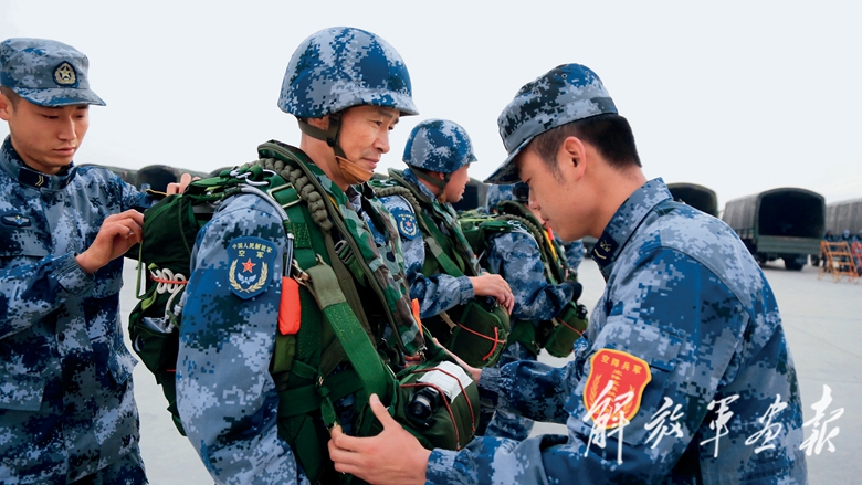图为在空降兵某旅进行大飞机集群伞降训练中,该旅政委姚恒文(中)准备